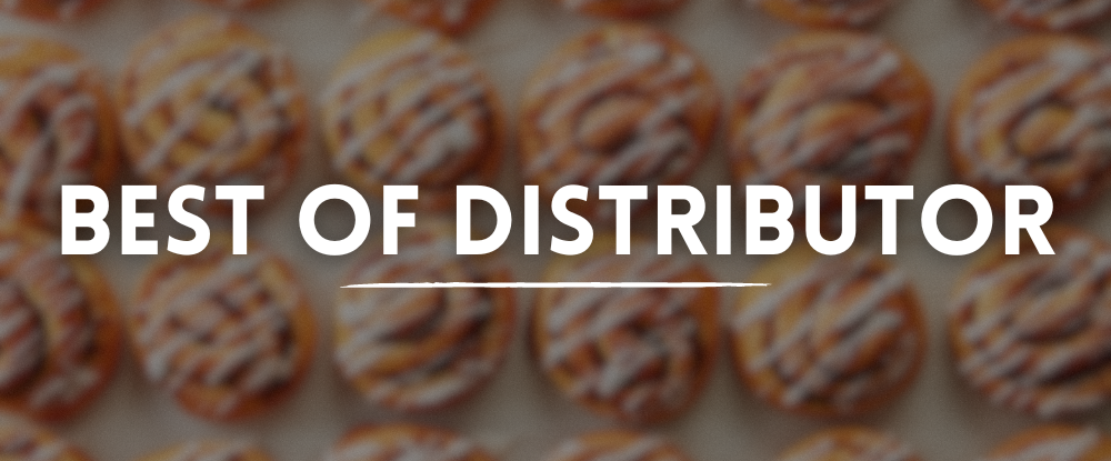 Blurred rows of frosted cinnamon rolls on a baking sheet with white text “Best Of Distributor” overlay