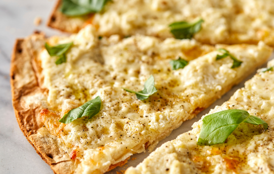 A closeup of Bianca Pizza slices showcasing a crispy, parbaked BONICI® crust with gourmet toppings.