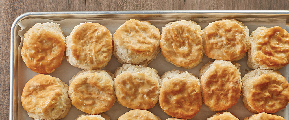 Many General Mills Pillsbury biscuits baked on a tray in a foodservice operation