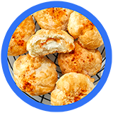 Golden brown, fluffy cheese balls in a wire basket, with one halved to reveal a gooey cheese filling. Perfectly baked snack!