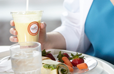white plate with food and woman holding a smootie